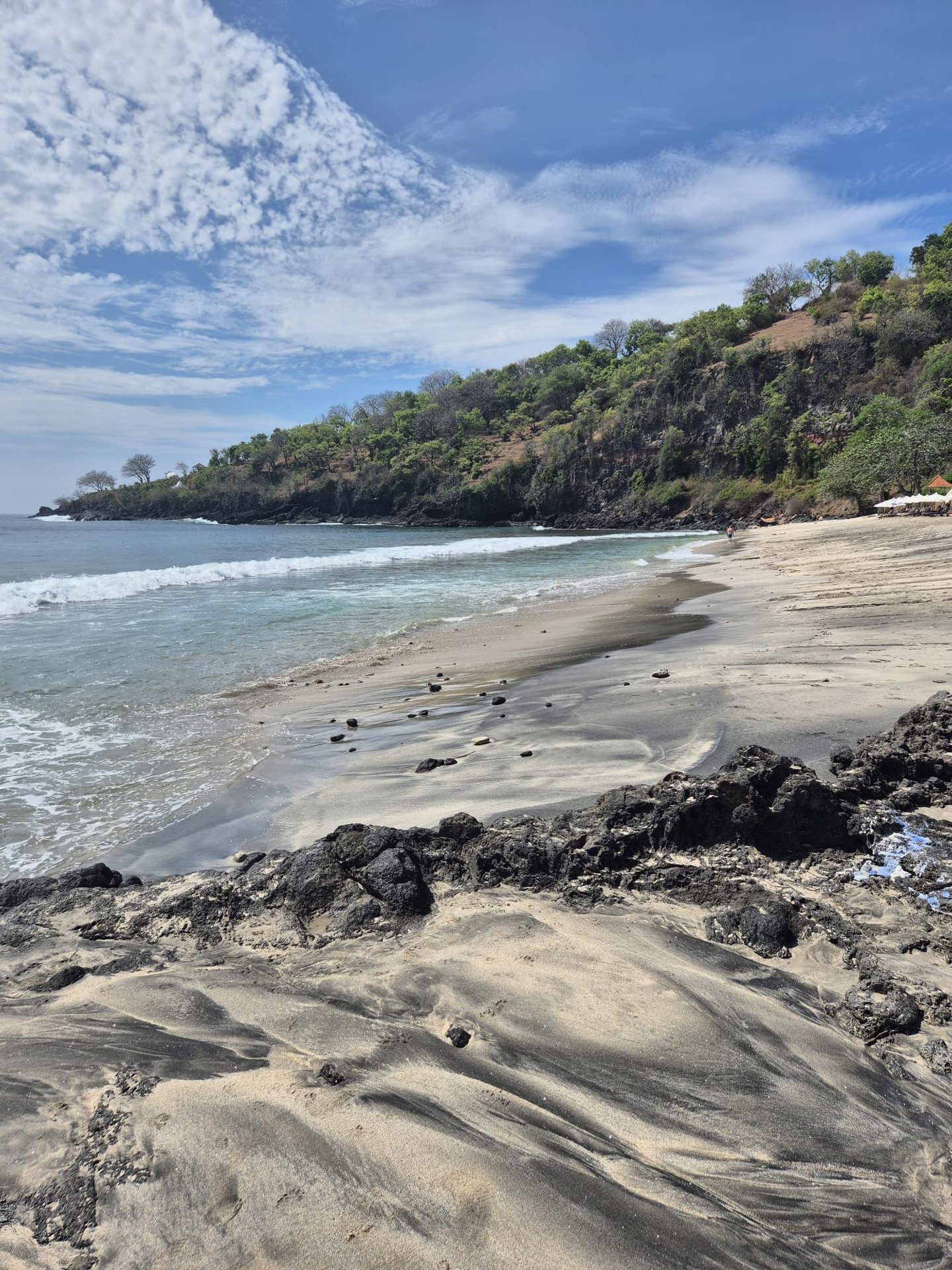 Pláž s černými lávovými skalami na východním Bali